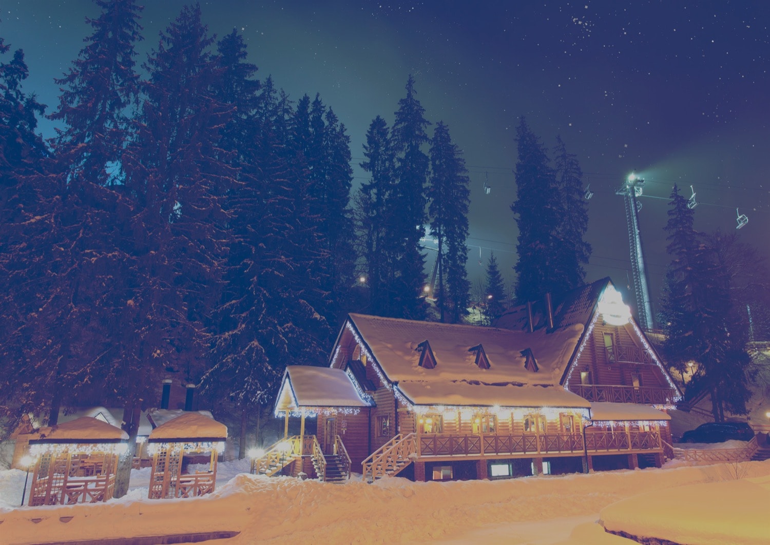 Ski Chalet and lift in the middle of the night, covered in snow. 